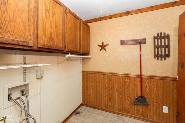 laundry room featuring cabinets, wooden walls, hookup for a washing machine, and light wood-type flooring