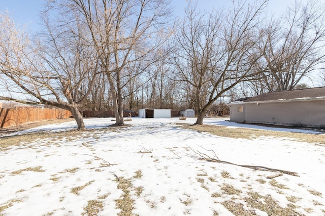 yard covered in snow with a storage shed