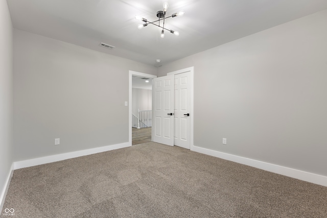 unfurnished bedroom featuring carpet flooring, a notable chandelier, and a closet