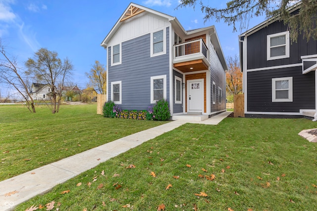 view of front of house with a balcony and a front yard