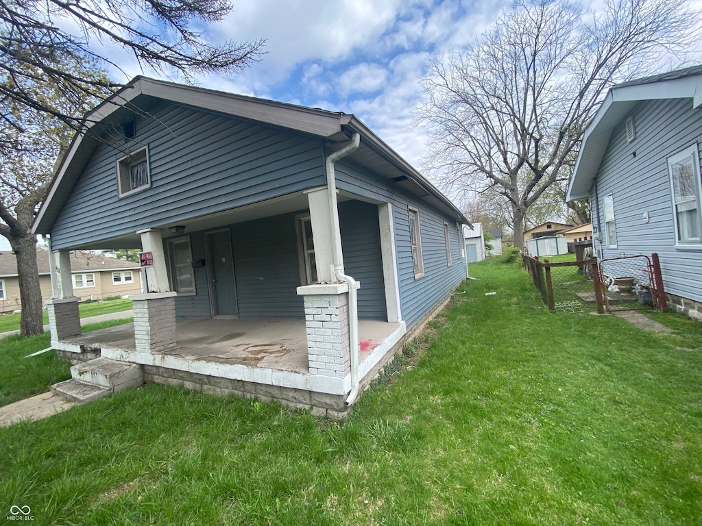 view of home's exterior featuring a porch and a yard