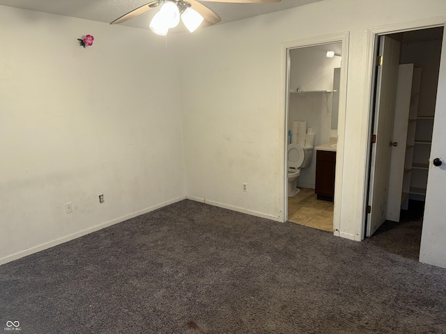 unfurnished bedroom featuring light colored carpet, ensuite bath, and ceiling fan