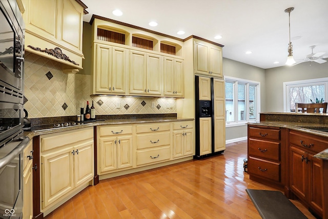 kitchen with hanging light fixtures, light hardwood / wood-style flooring, ceiling fan, gas stovetop, and cream cabinetry