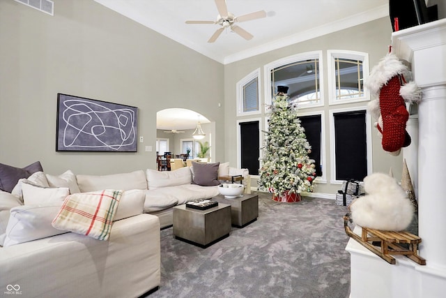 living room featuring carpet, a towering ceiling, ceiling fan, and ornamental molding