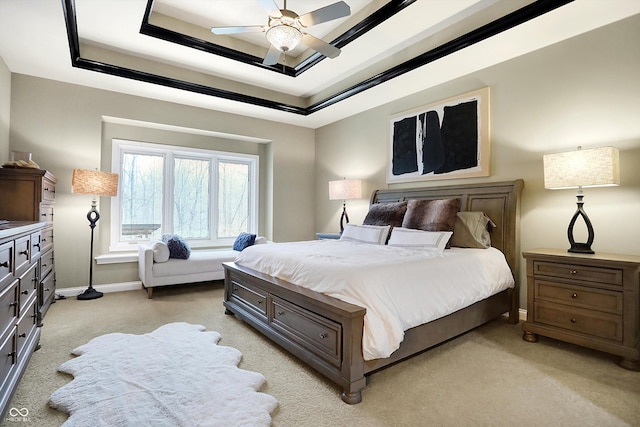 bedroom with ceiling fan and a tray ceiling