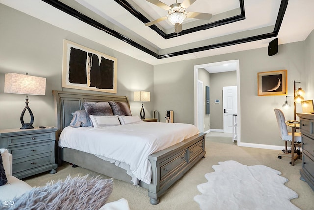 carpeted bedroom featuring a tray ceiling and ceiling fan