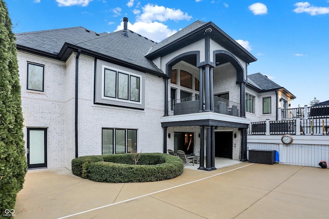 view of front of house featuring central AC, a balcony, and a patio