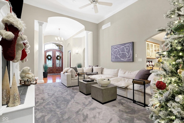 living room featuring carpet flooring, ceiling fan with notable chandelier, and french doors