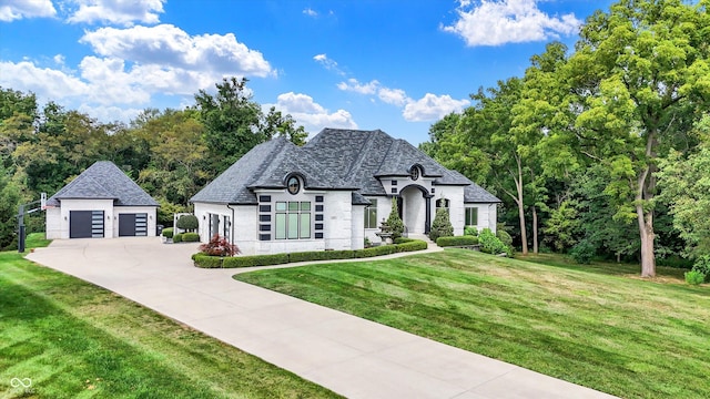 french provincial home with an outbuilding, a front lawn, and a garage