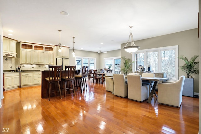 dining area with ceiling fan, a healthy amount of sunlight, and light wood-type flooring