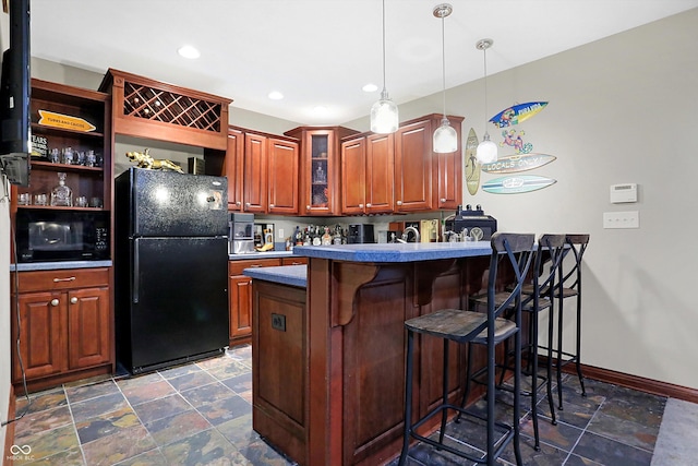 kitchen with a kitchen bar, kitchen peninsula, black appliances, and decorative light fixtures