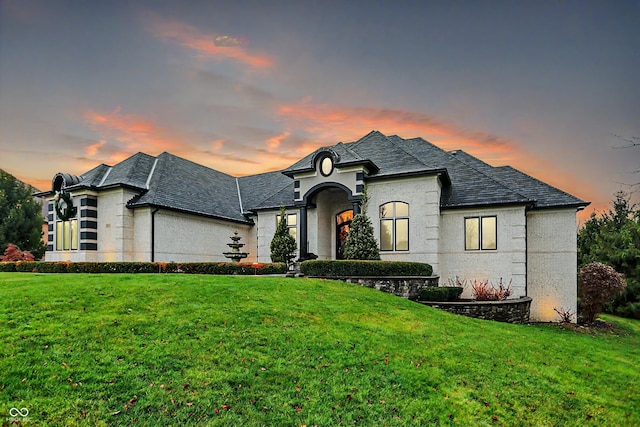 french country home featuring a lawn