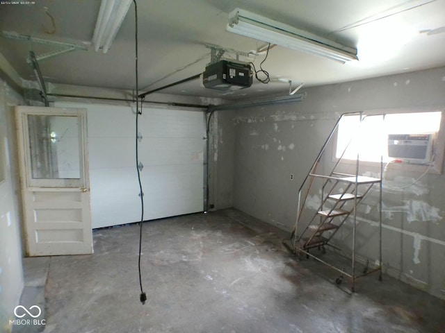 garage featuring a garage door opener and a wall mounted AC