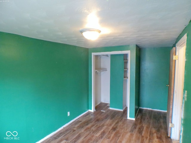 unfurnished bedroom with a closet and wood-type flooring