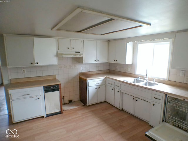 kitchen featuring tasteful backsplash, sink, white cabinets, and light wood-type flooring