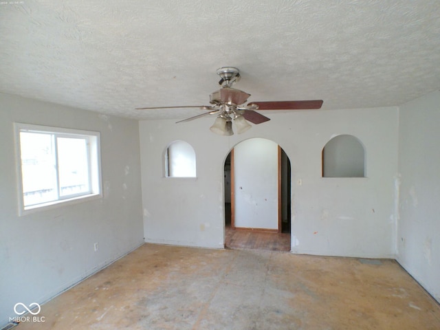 empty room with a textured ceiling and ceiling fan