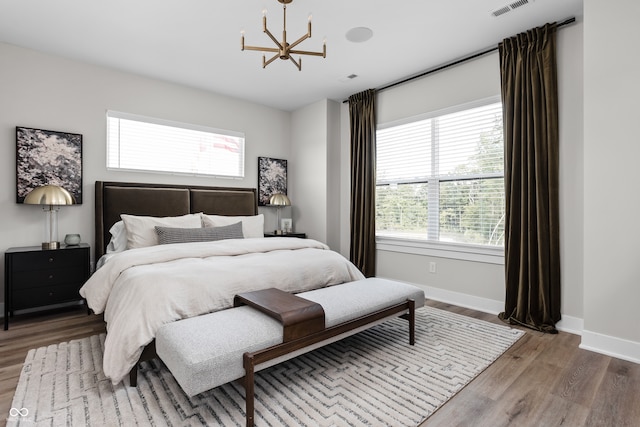 bedroom with hardwood / wood-style flooring and a notable chandelier