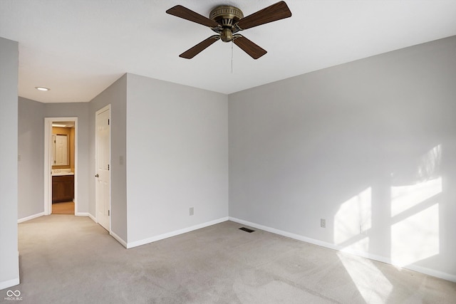 carpeted spare room featuring ceiling fan