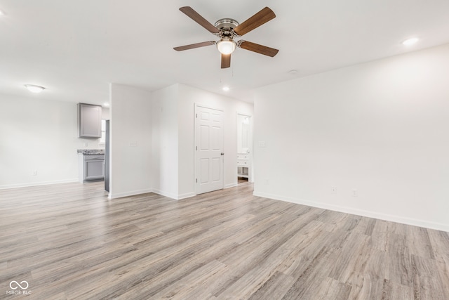 unfurnished living room with ceiling fan and light hardwood / wood-style flooring