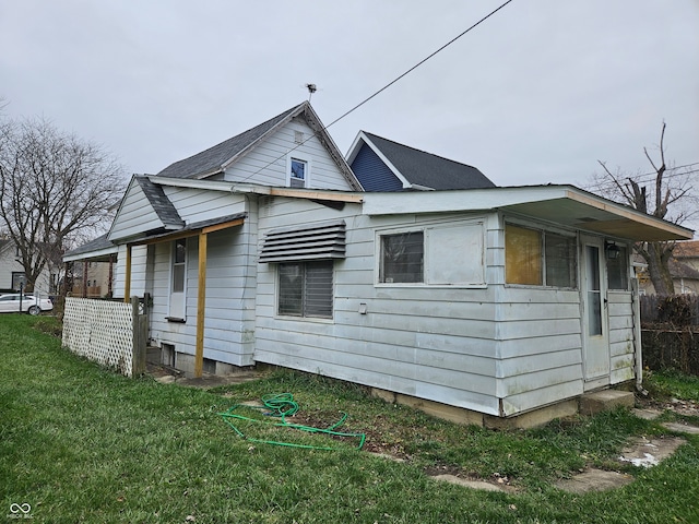 rear view of house featuring a yard