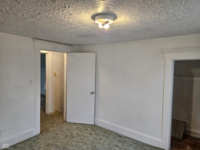 unfurnished bedroom with a textured ceiling, carpet floors, and a closet