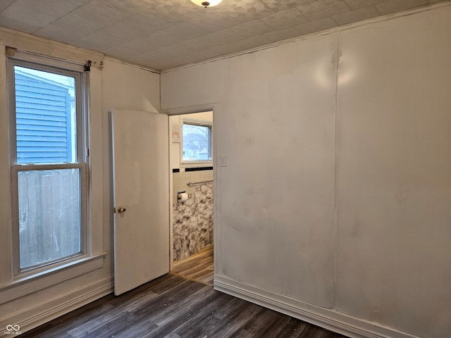 empty room with dark wood-type flooring and a healthy amount of sunlight