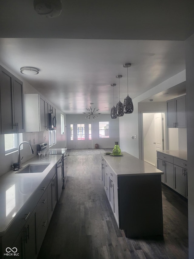 kitchen featuring appliances with stainless steel finishes, a kitchen island, a wealth of natural light, and gray cabinetry