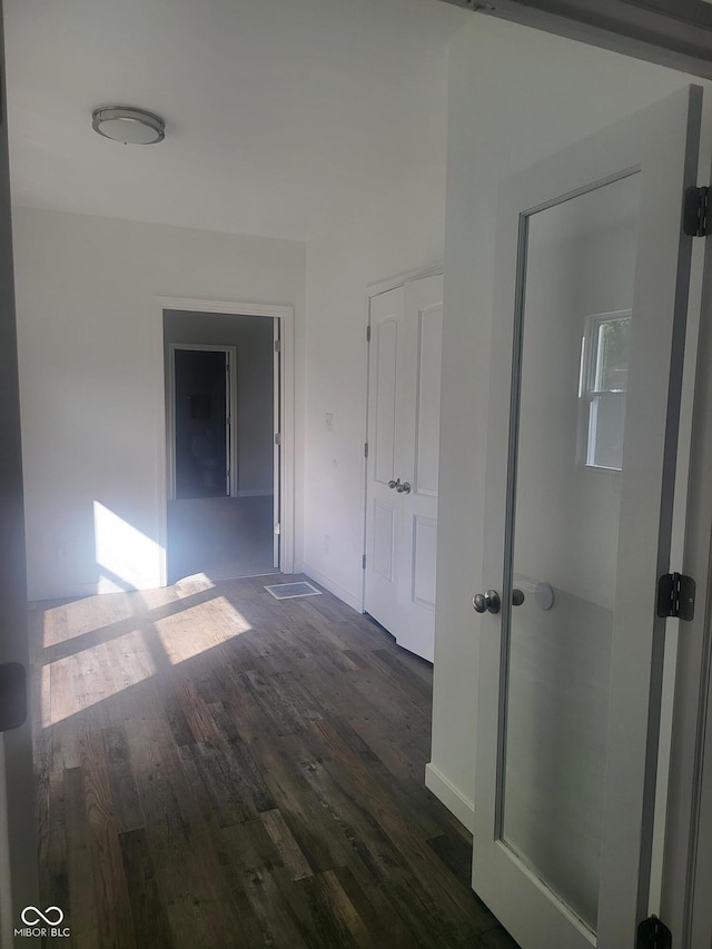 corridor with dark hardwood / wood-style flooring