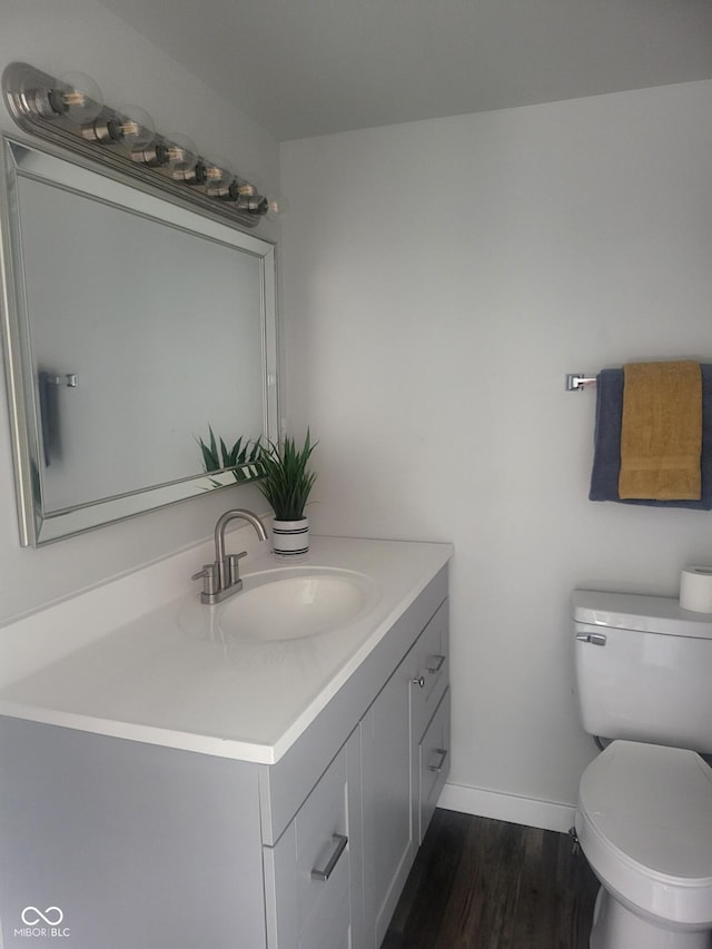 bathroom with hardwood / wood-style floors, vanity, and toilet