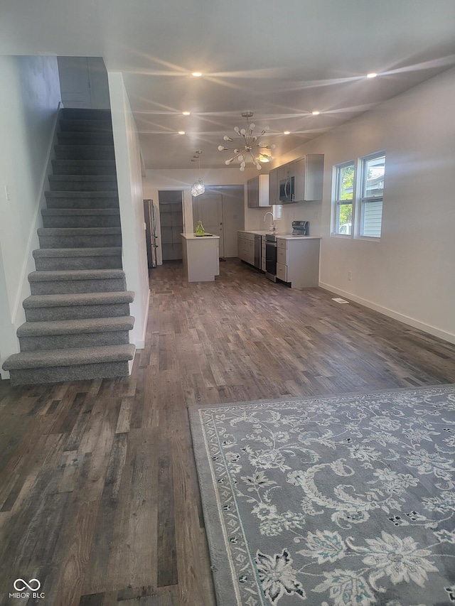 unfurnished living room featuring sink and dark wood-type flooring