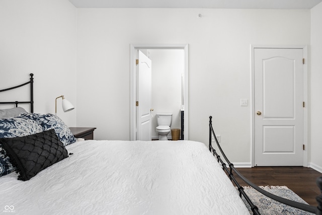 bedroom featuring connected bathroom and dark wood-type flooring