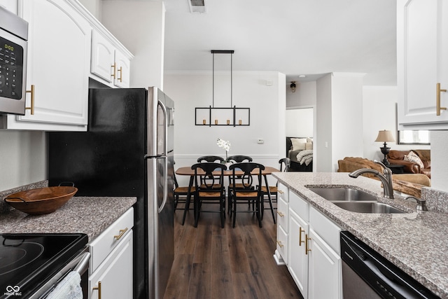 kitchen with sink, hanging light fixtures, dark wood-type flooring, white cabinets, and appliances with stainless steel finishes