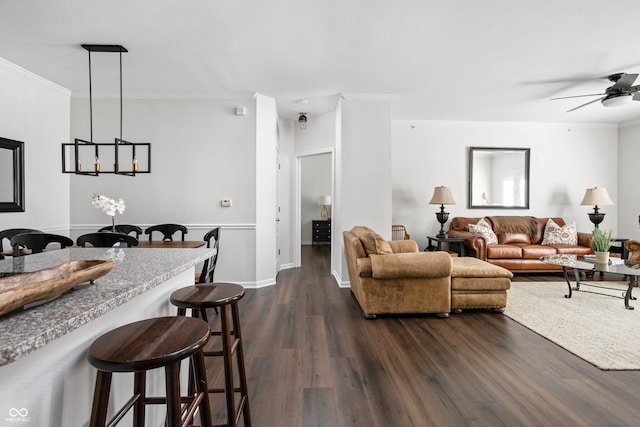 living room with ceiling fan, dark hardwood / wood-style flooring, and ornamental molding