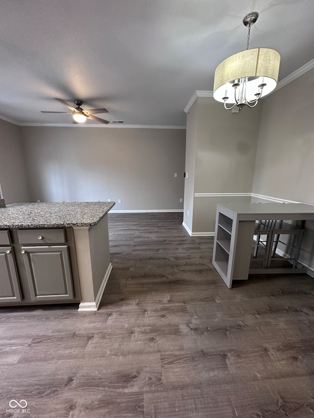 kitchen with dark hardwood / wood-style floors, crown molding, hanging light fixtures, and ceiling fan with notable chandelier