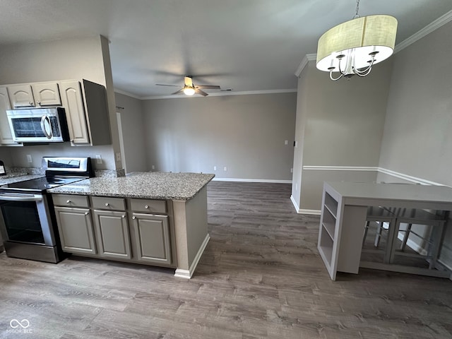 kitchen with kitchen peninsula, hardwood / wood-style flooring, pendant lighting, and appliances with stainless steel finishes