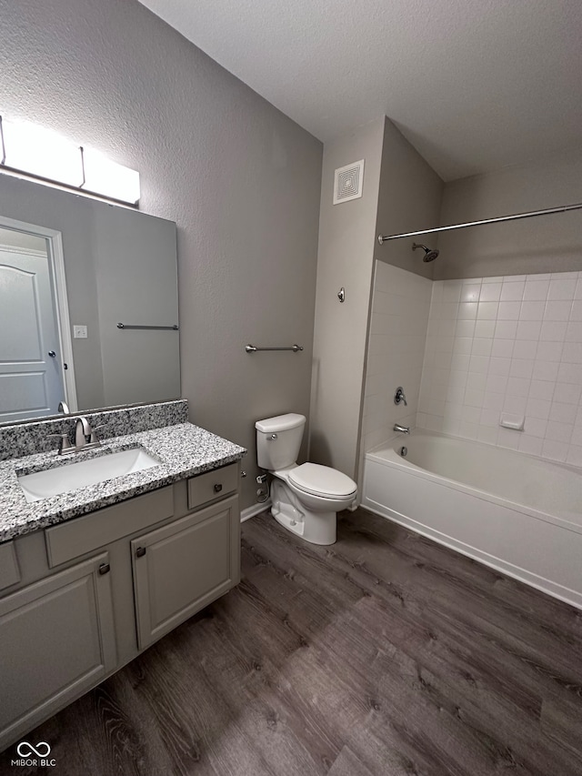 full bathroom featuring wood-type flooring, vanity, toilet, and  shower combination