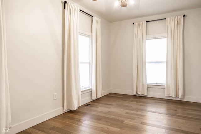 unfurnished room featuring ceiling fan, a healthy amount of sunlight, and light hardwood / wood-style floors