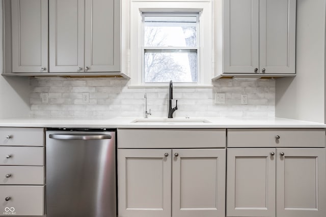 kitchen featuring gray cabinetry, dishwasher, decorative backsplash, and sink