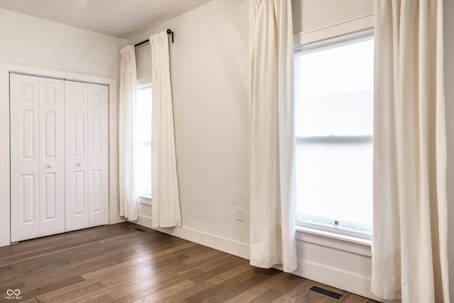 unfurnished bedroom with a closet and hardwood / wood-style flooring