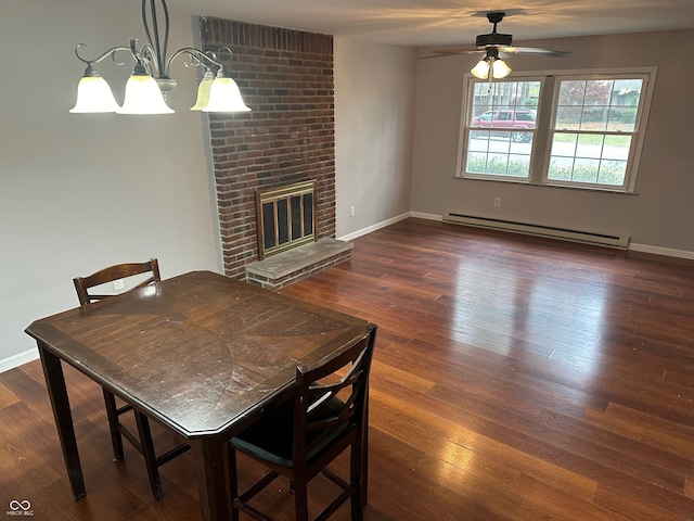 dining area featuring ceiling fan with notable chandelier, dark hardwood / wood-style flooring, a brick fireplace, and baseboard heating