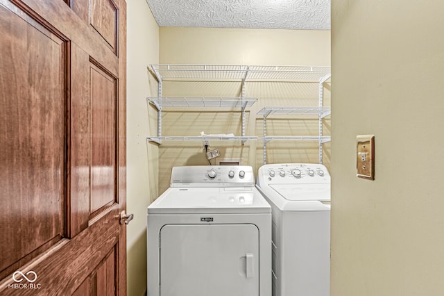 laundry room with separate washer and dryer and a textured ceiling