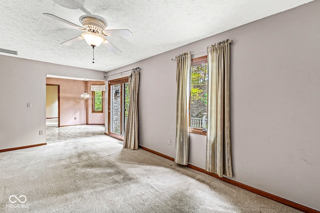 empty room featuring light carpet, ceiling fan, and a textured ceiling