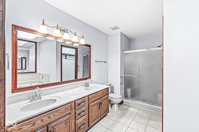 full bathroom with tile patterned floors, vanity, plus walk in shower, and a textured ceiling