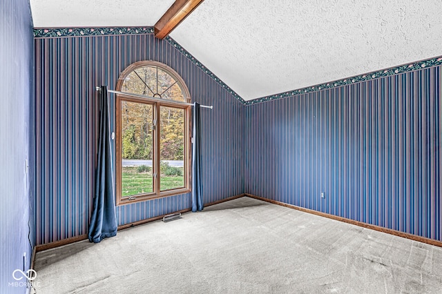 unfurnished room with carpet flooring, lofted ceiling with beams, and a textured ceiling