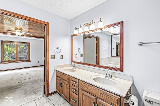 bathroom with vanity, a textured ceiling, ceiling fan, tile patterned flooring, and toilet