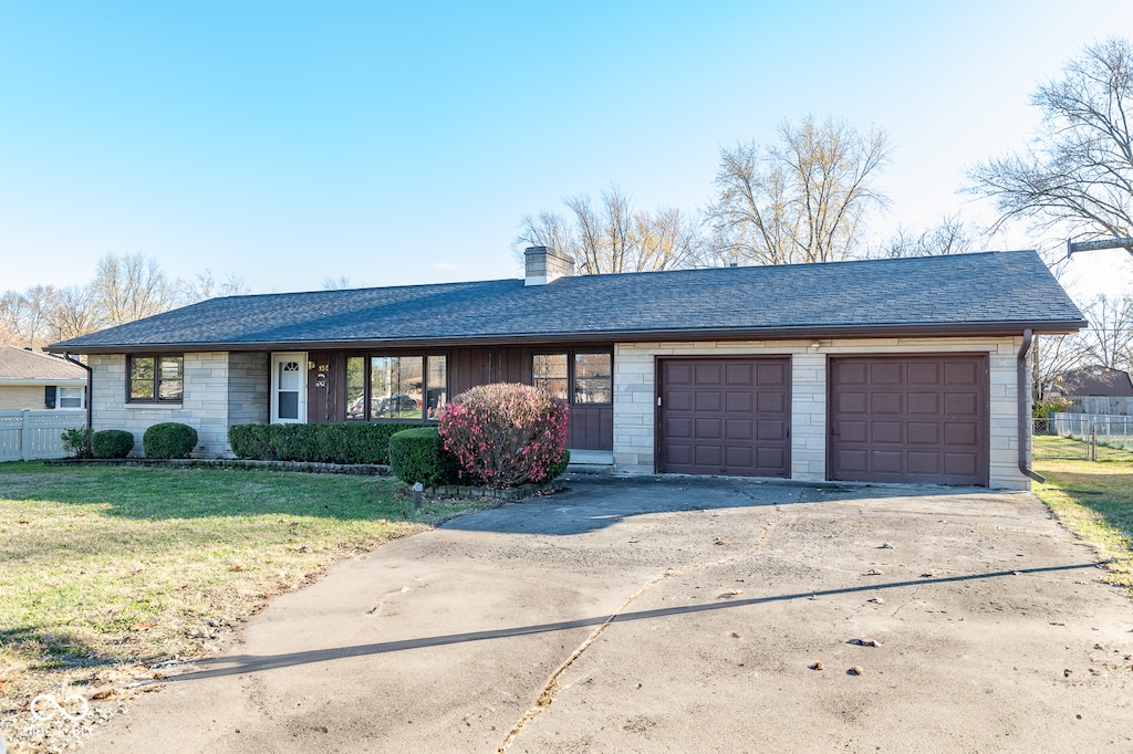 ranch-style house featuring a front lawn and a garage