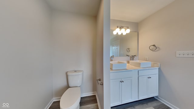 bathroom with vanity, hardwood / wood-style flooring, and toilet