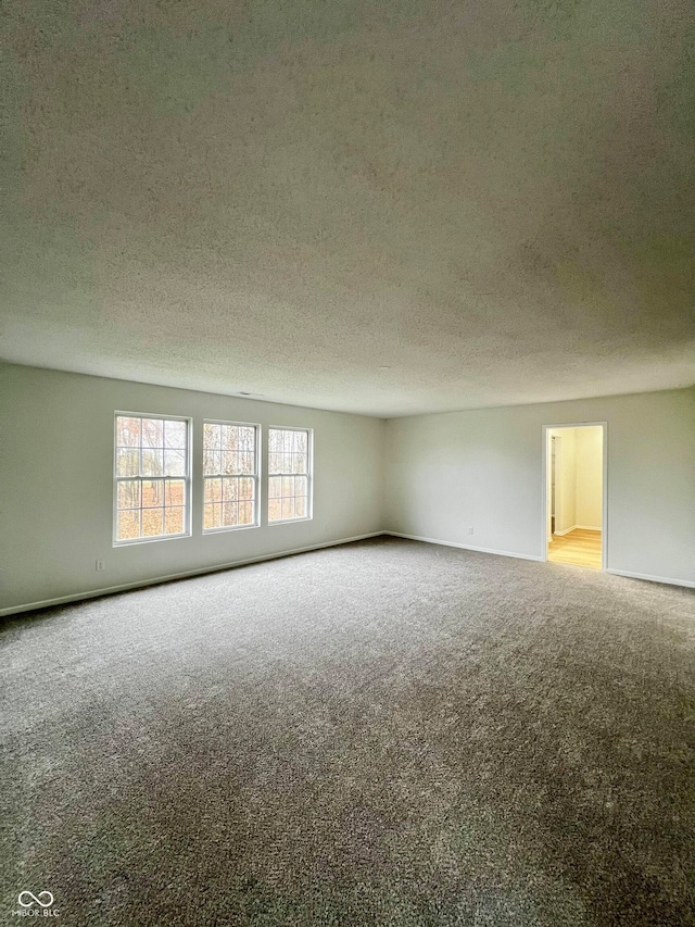 carpeted empty room featuring a textured ceiling