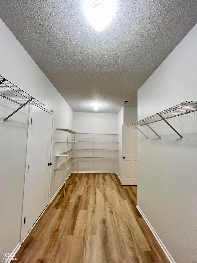 spacious closet featuring light hardwood / wood-style floors