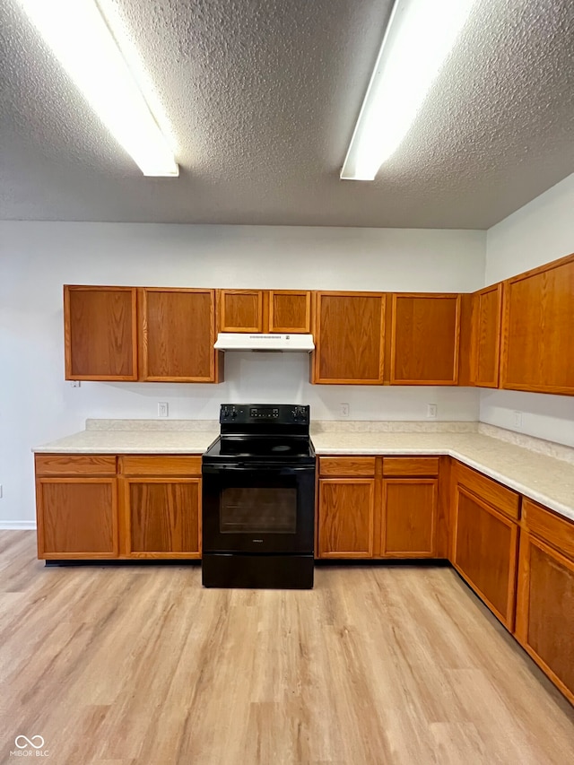 kitchen with light hardwood / wood-style floors, a textured ceiling, and black / electric stove